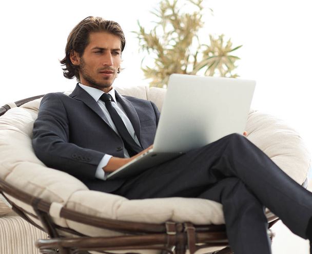 successful businessman with laptop sitting in a large comfortable armchai - Photo, Image