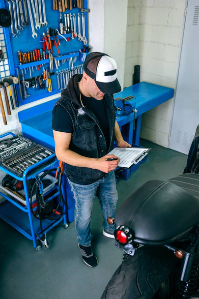 Mechanic checking motorcycle - Valokuva, kuva