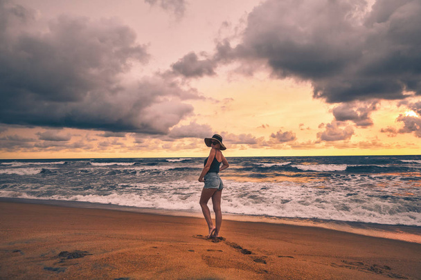 Krásná dívka ve tvaru na ocean pobřeží Srí Lanky. Barevné obloha s mraky na pozadí - Fotografie, Obrázek