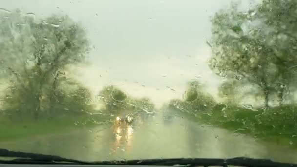O carro se move ao longo da estrada durante a chuva e remove as gotas do pára-brisas
 - Filmagem, Vídeo