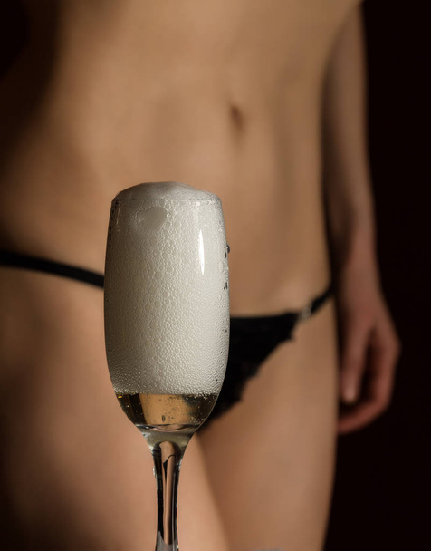 sexy body woman in black underwear pours champagne in glass - Photo, image
