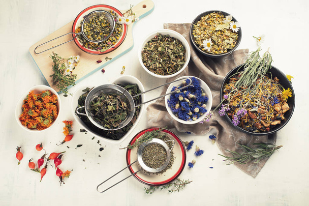 Various herbal tea ingredients and dried flowers on white background - Фото, зображення