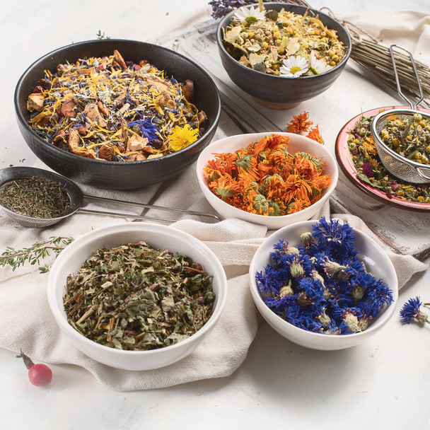 Dried herbs and flowers in bowls with sieves - Fotografie, Obrázek