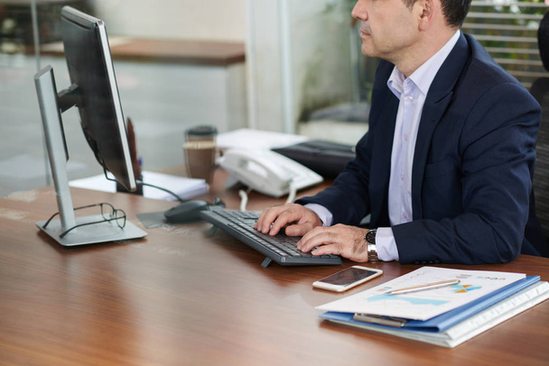 Cropped image of businessman working on computer in office  - Photo, Image