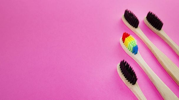 Escovas de dentes de madeira preto e arco-íris em fundo azul. Conceito de racismo, exclusão social, depressão ou solidão, problemas sociais ou migração ilegal
 - Foto, Imagem
