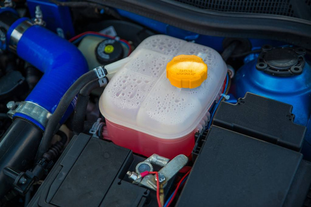 Plastic cooling liquid tank in car engine. Antifreeze radiator liquid - Photo, Image