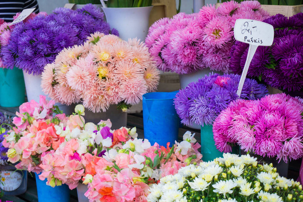 verschiedene Herbstblumen zum Verkauf auf dem zentralen Markt in Sträußen mit Preisen - Foto, Bild