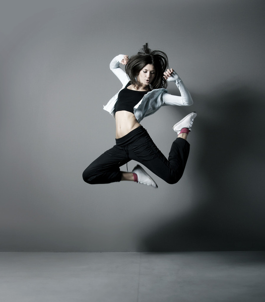 Young and sexy modern dancer over grey background - 写真・画像