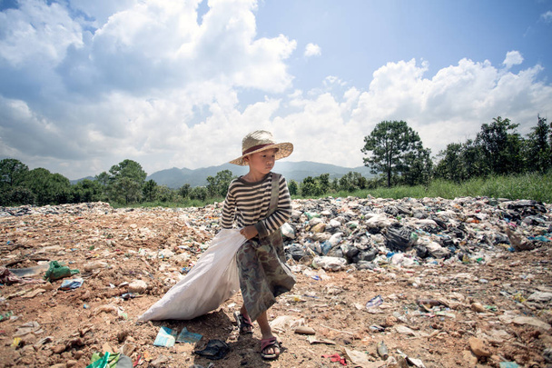 Los niños encuentran chatarra para la venta y la reciclan en vertederos, las vidas y los estilos de vida de los pobres, los conceptos de pobreza y medio ambiente
 - Foto, imagen