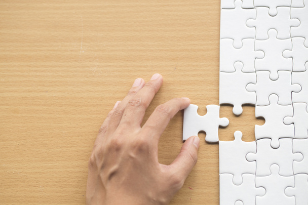  hand placing the last jigsaw puzzle piece, conceptual of problem solving
 - Фото, изображение