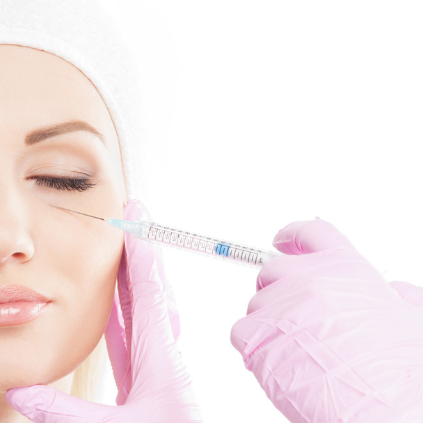 Beautiful woman gets an injection in her face - Foto, Bild