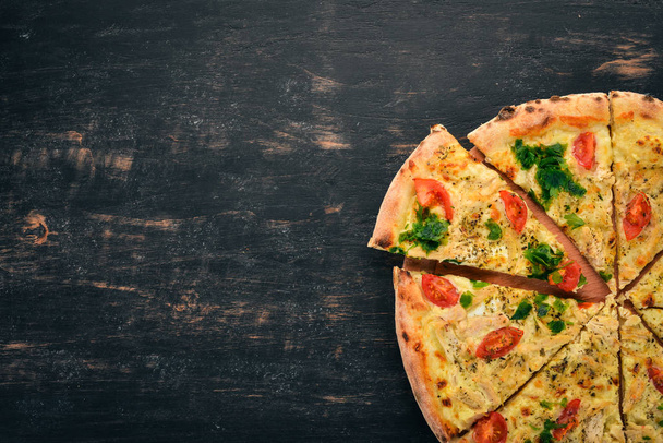 Pizza with cherry tomatoes, suluguni cheese and basil. Italian cuisine. On a wooden background. Free space for text. Top view. - Foto, Imagem