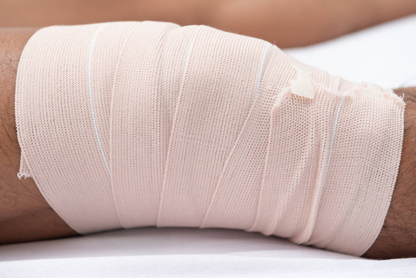 Fisioterapeutas usam as alças na perna do paciente para se deitar na cama em uma sala médica
. - Foto, Imagem