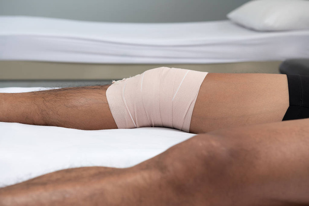 Fizyoterapistler hastanın bacağından bir sağlık odası yatakta yalan için tutamaçları kullanın. - Fotoğraf, Görsel