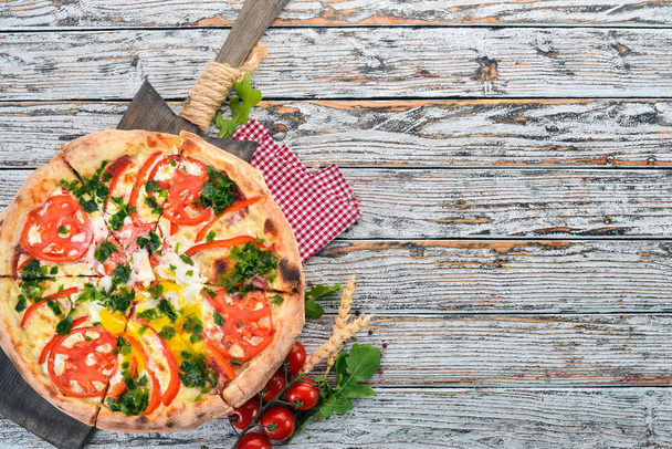 Pizza with vegetables and poached egg. Italian cuisine. On a wooden background. Free space for text. Top view. - 写真・画像