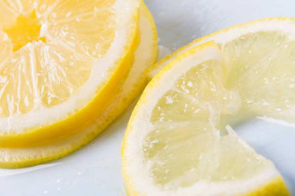 Sliced lemon on a blue cutting Board. Fresh juicy lemon slices. Food background - Fotografie, Obrázek