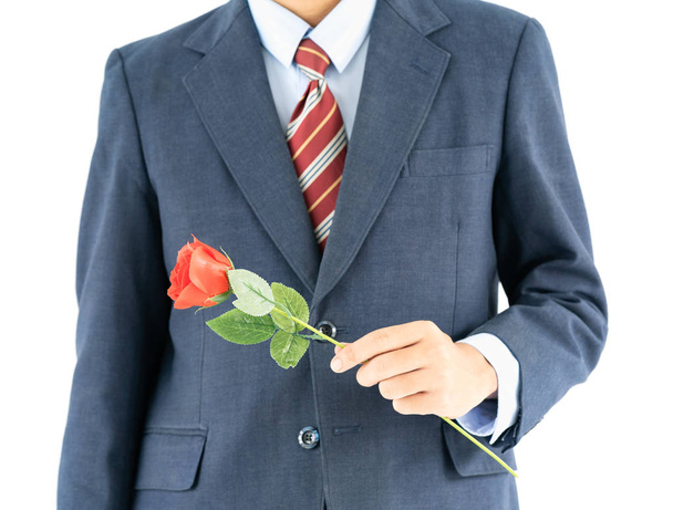 Close up photo of businessman in suit holding with red rose on white background - Foto, afbeelding