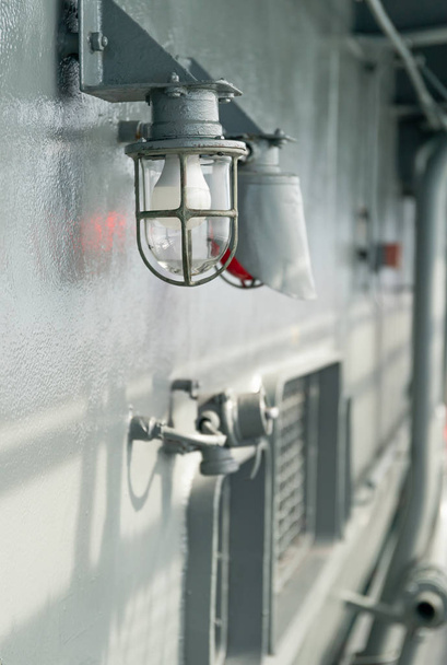 Lampe de pont à bord du navire avec cadre métallique fixé dans une cage de protection
 - Photo, image