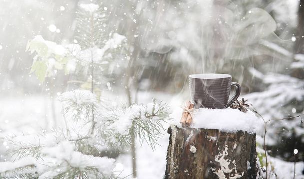 Чашка з гарячим напоєм у зимовому лісі. Гаряче какао з корицею
 - Фото, зображення