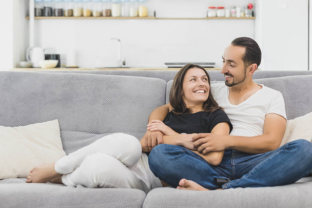 happy couple hugging on the couch at home and relaxing togetherness - 写真・画像