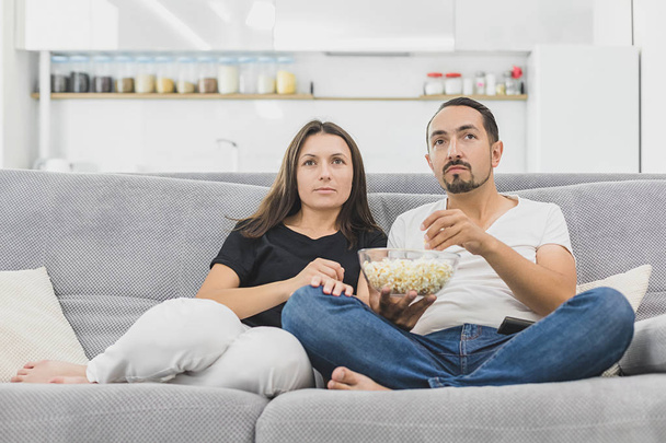 Young couple with popcorn on the sofa watching a movie - Φωτογραφία, εικόνα