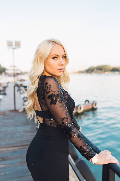 Beautiful young blonde woman posing at dock with yachts on background. summer time concept - Фото, зображення
