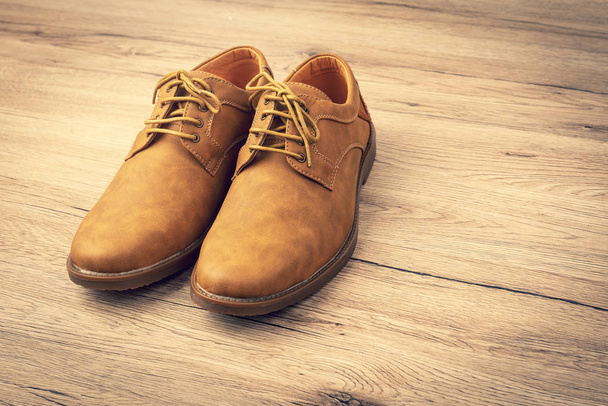 Zapatos de cuero de corte marrón en piso de madera, estilo Vintage
 - Foto, imagen