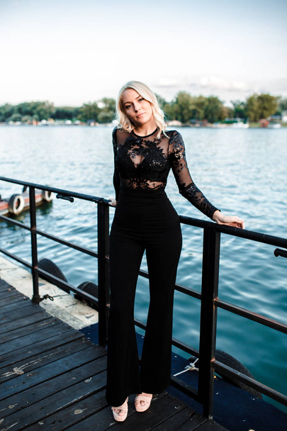 Beautiful young blonde woman posing at dock with yachts on background. summer time concept - Photo, Image