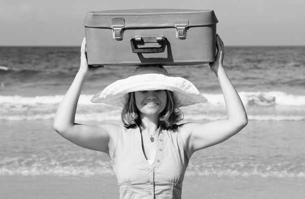 young woman standing on the beach with vintage suitcase - Photo, Image