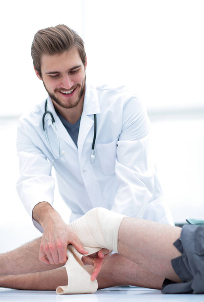 arts kijken naar de bandage op het been van de patiënten - Foto, afbeelding