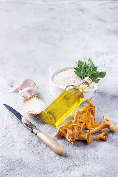 Ingredientes de cogumelos Risotto: cogumelos chanterelle, arroz de arborio, alho, vinho, salsa de cebola e óleo de azeitona sobre um conselho de pedra
 - Foto, Imagem