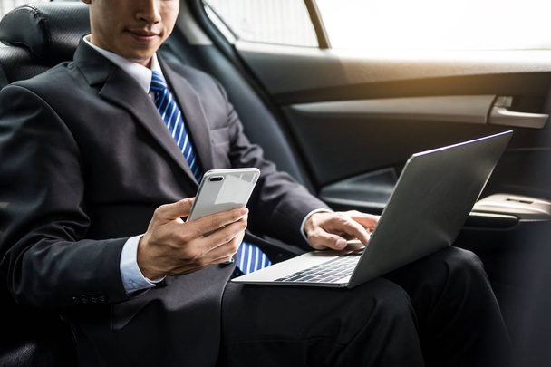 Atractivo joven empresario guapo utilizando el teléfono inteligente móvil en el coche
. - Foto, imagen