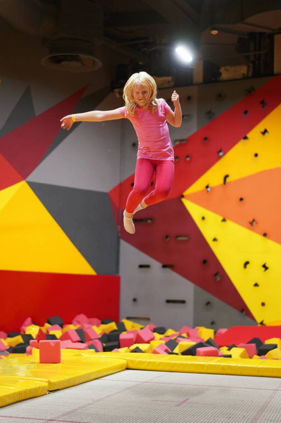 infância feliz de uma criança moderna na cidade - menina pulando no parque de trampolim
 - Foto, Imagem