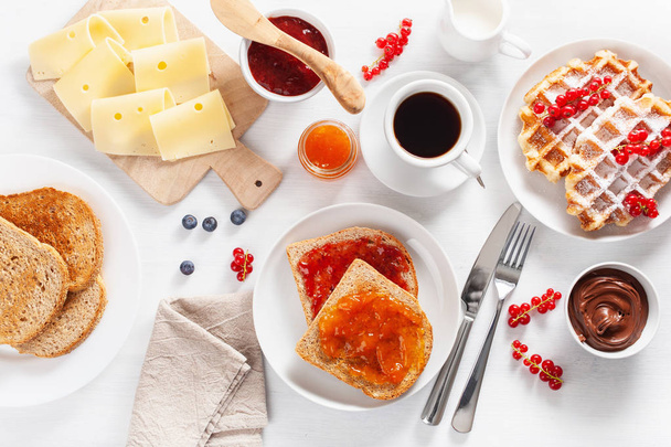 breakfast with waffle, toast, berry, jam, chocolate spread and coffee. Top view - Photo, Image
