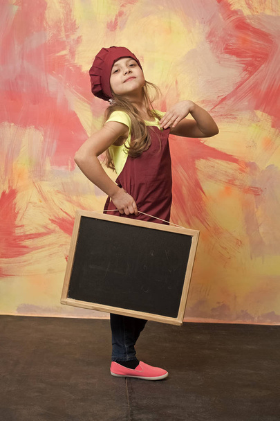 small happy girl chef in hat, apron with blackboard - 写真・画像