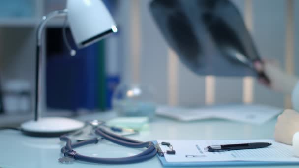Ärztin hält Röntgenbild in der Hand. Medizinische Diagnostik am Arbeitsplatz des Arztes - Filmmaterial, Video