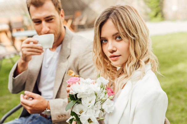 attrayant petite amie tenant bouquet de roses dans le café, petit ami boire du café
 - Photo, image