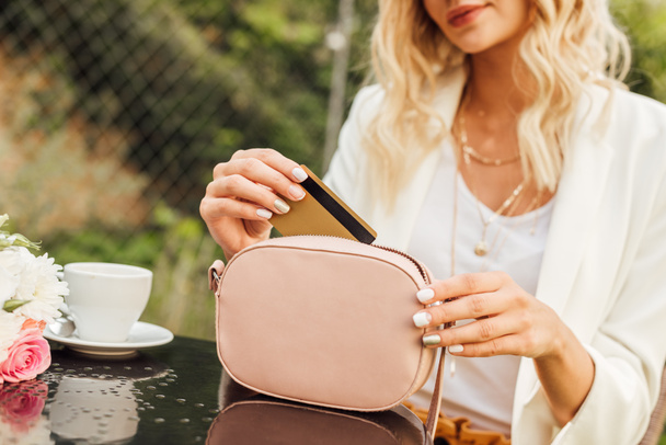 imagen recortada de la mujer que toma la tarjeta de crédito del bolso en la cafetería
 - Foto, Imagen