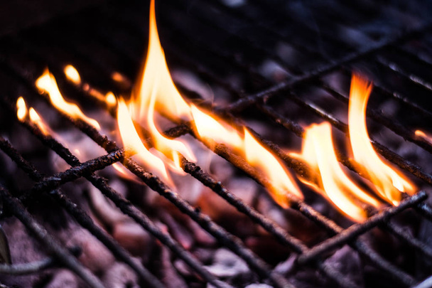 Fuego de carbón caliente bajo parrilla barbacoa tiro nocturno de primer plano con enfoque suave
 - Foto, Imagen