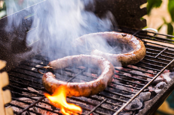 Σπιτικό λουκάνικο Μπάρμπεκιου Γκριλ μαγειρέματος και Closeup κάρβουνο φωτιά κάτω από το κάπνισμα - Φωτογραφία, εικόνα