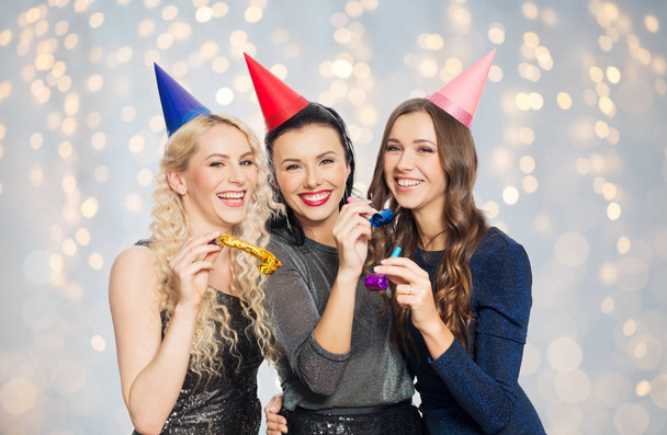 happy women with party hats hugging - Foto, Imagem