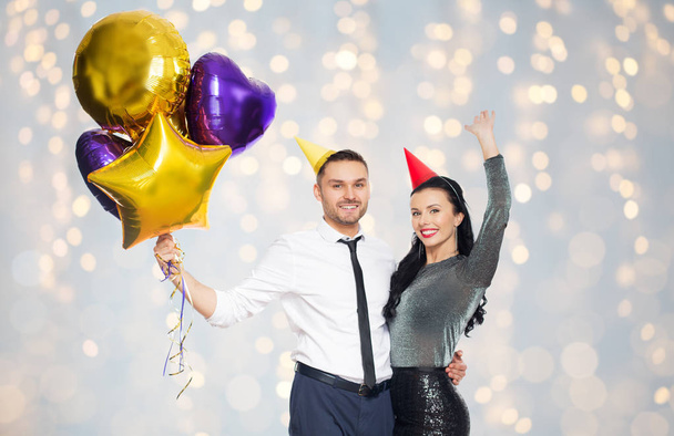 happy couple in party hats with balloons - Φωτογραφία, εικόνα