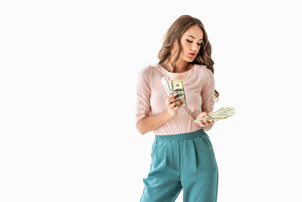 красивая молодая женщина, считая долларовые купюры, изолированные на белом
 - Фото, изображение