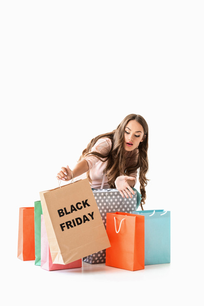 surprised girl holding shopping bags for black friday, isolated on white - Photo, Image