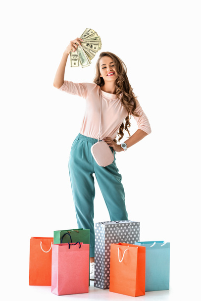 chica feliz sosteniendo dólares y bolsas de compras, aislado en blanco
 - Foto, imagen