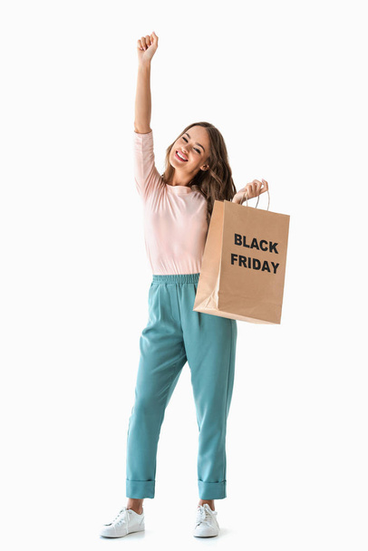 heyecanlı kız alışveriş çantası üzerinde beyaz izole siyah Cuma işaretiyle holding - Fotoğraf, Görsel