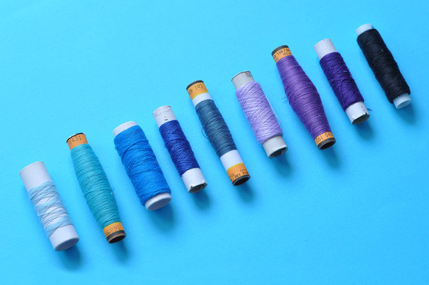 blue thread reels for sewing on a blue background. photo thread on. threads of shades of blue. sewing, needlework, handmade. Use for backgrounds, wallpapers, posters, advertisements, card - Photo, Image