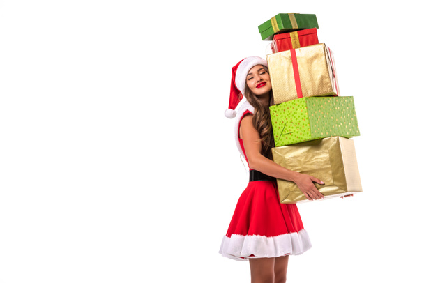 attractive dreamy girl in santa costume holding gift boxes, isolated on white - Foto, afbeelding