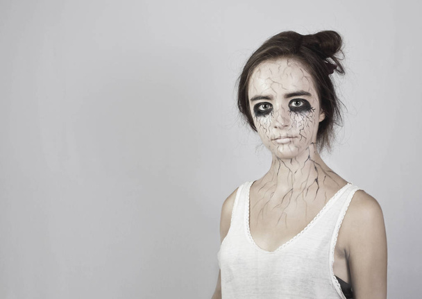 Halloween. Portrait of a sad girl with bruises under her eyes and black veins on her face. concept of halloween and day of the dead. - Photo, Image