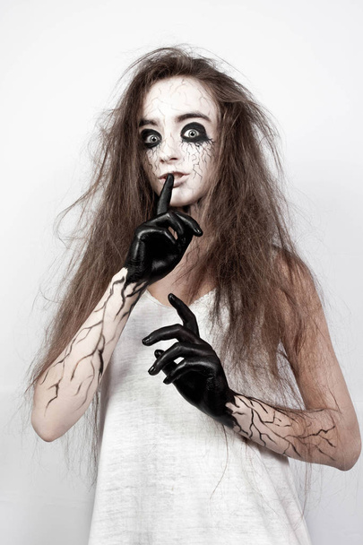 bláznivá holka s rozcuchanými vlasy, černé oči a žíly ukazuje její prst ššš. Koncept Halloween. Detailní záběr. - Fotografie, Obrázek